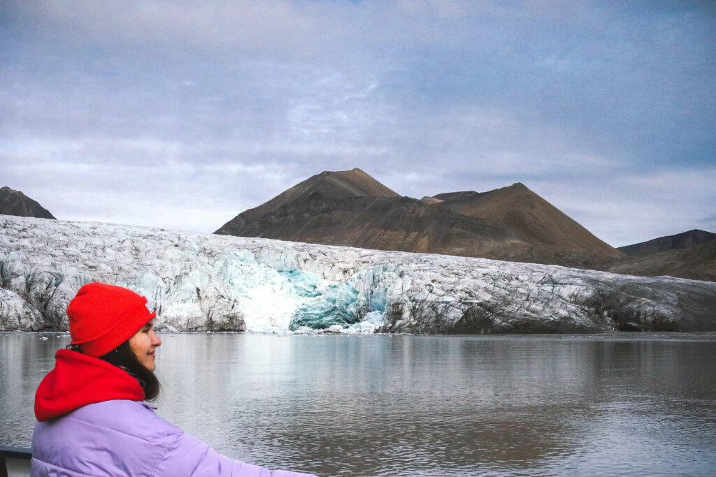 girl in orange hat in front of Nordenskiöld Glacier